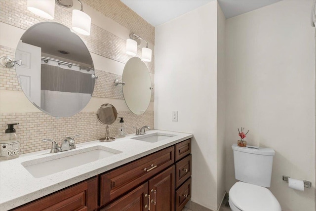 full bathroom with tasteful backsplash, double vanity, toilet, and a sink