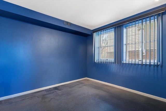 empty room featuring visible vents, carpet, and baseboards