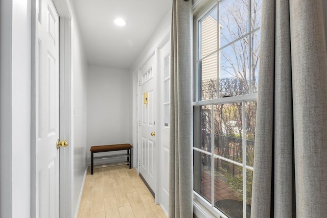 corridor featuring light wood finished floors and a wealth of natural light