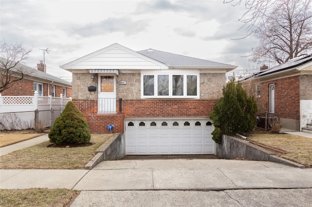 bungalow-style house featuring a garage, driveway, stone siding, fence, and brick siding