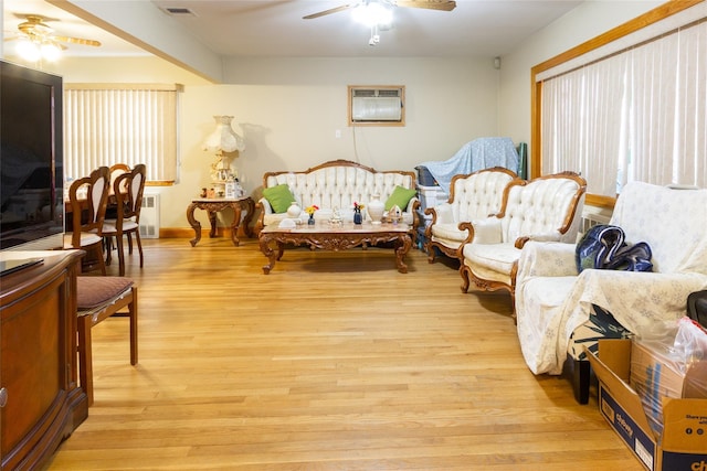 bedroom with visible vents, multiple windows, a wall mounted air conditioner, and light wood-style flooring