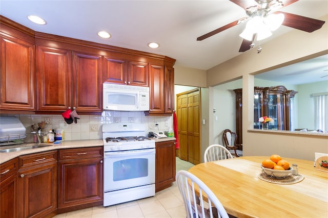 kitchen featuring light countertops, white appliances, a sink, and decorative backsplash