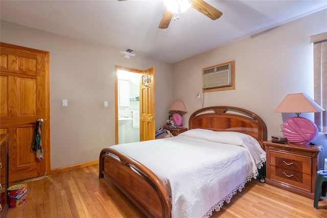 bedroom with light wood-type flooring, visible vents, baseboards, and a wall mounted air conditioner