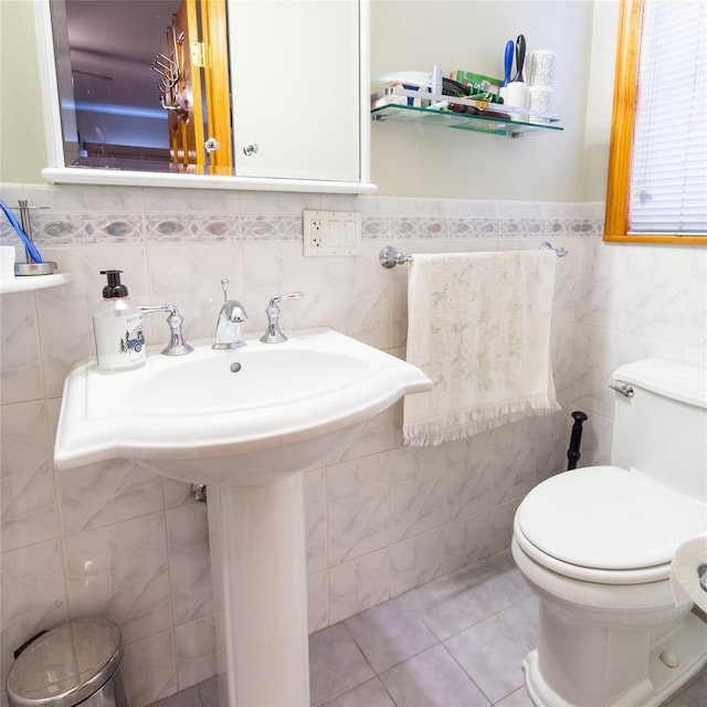 bathroom featuring tile patterned flooring, tile walls, and toilet