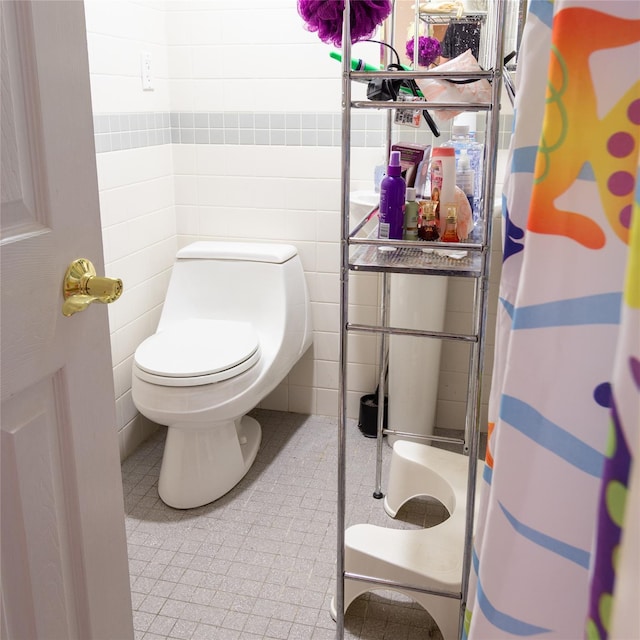 full bathroom with a shower with curtain, tile walls, and toilet