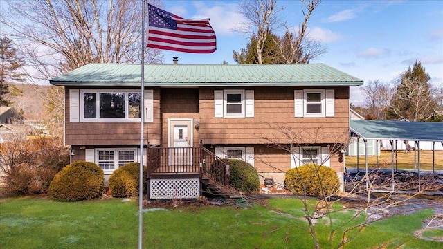 split foyer home with metal roof, a carport, and a front lawn