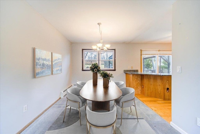 dining space with an inviting chandelier, baseboards, and baseboard heating