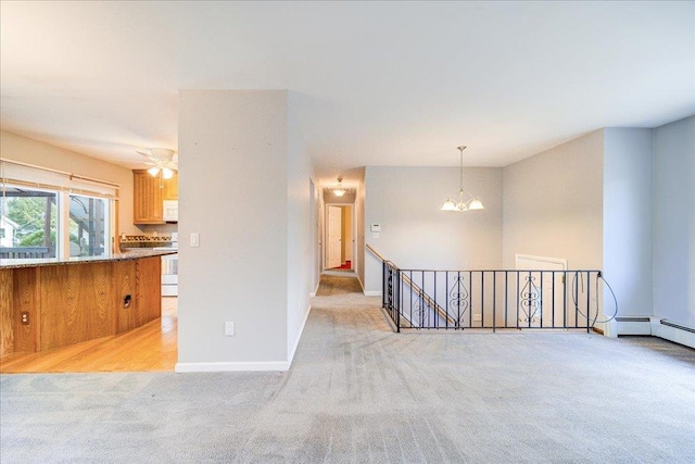 spare room featuring light carpet, baseboards, and an inviting chandelier