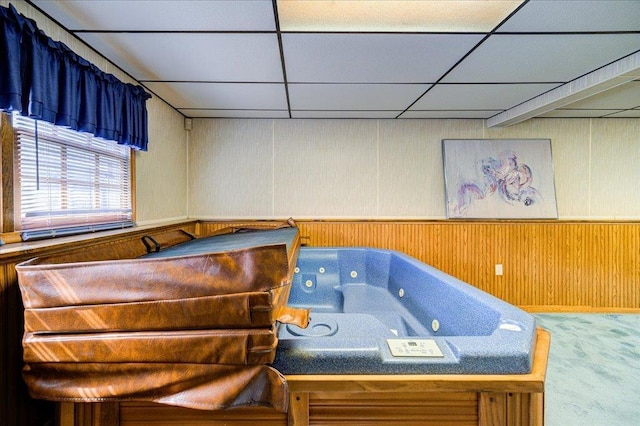 miscellaneous room featuring a paneled ceiling, a jacuzzi, carpet floors, and wood walls