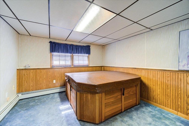 unfurnished office with a drop ceiling, carpet, and wood walls