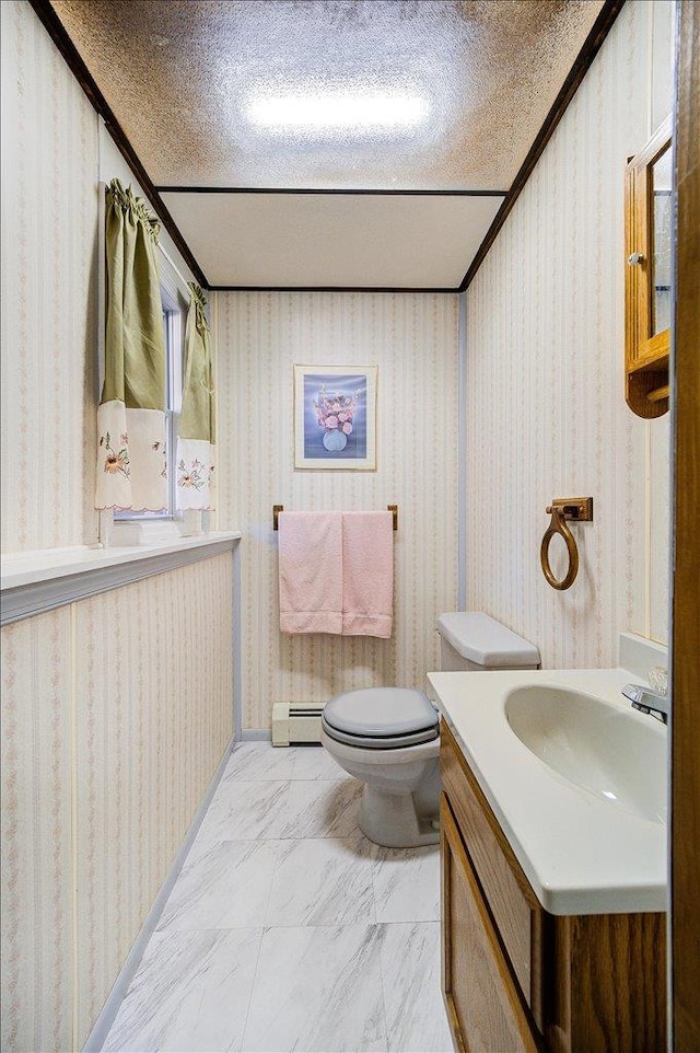 bathroom with vanity, wallpapered walls, a baseboard heating unit, toilet, and marble finish floor