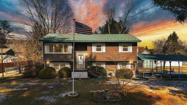 back of house at dusk featuring metal roof