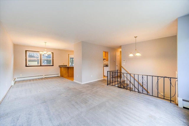 unfurnished room featuring a baseboard heating unit, carpet floors, a notable chandelier, and baseboards