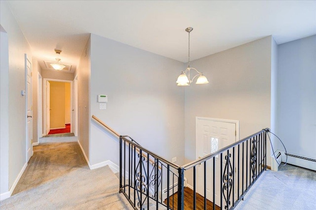 corridor featuring carpet, baseboards, an upstairs landing, an inviting chandelier, and a baseboard radiator