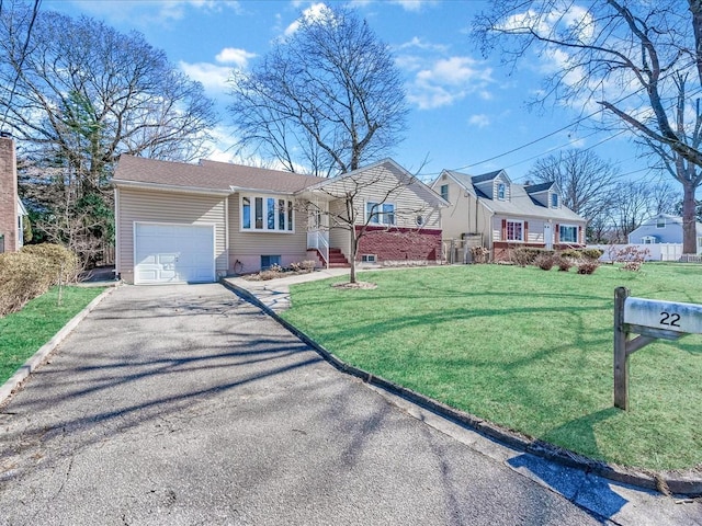 view of front of house featuring a garage, driveway, and a front lawn