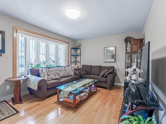 living area with light wood-style flooring, baseboards, and cooling unit