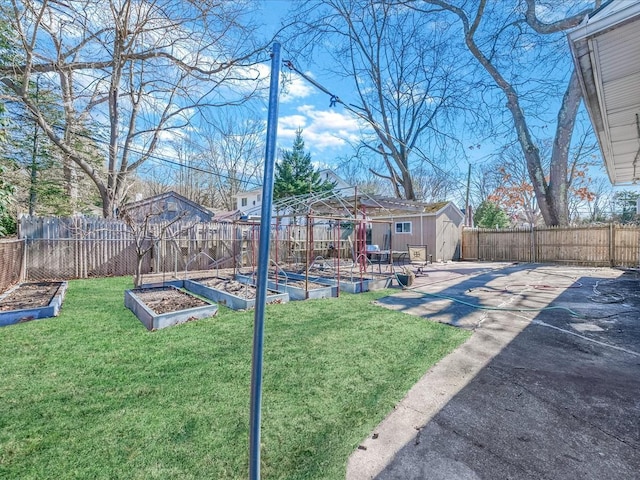 view of yard with an outbuilding, a garden, a fenced backyard, and a storage shed