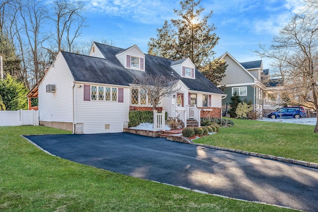 view of front of home featuring driveway, fence, and a front yard