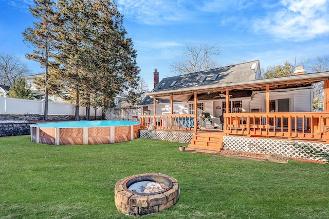 back of property featuring a fenced in pool, an outdoor fire pit, fence, and a chimney