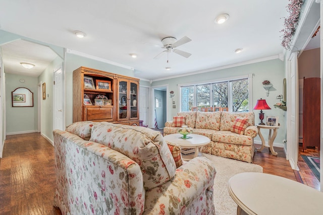 living room with baseboards, crown molding, and wood finished floors