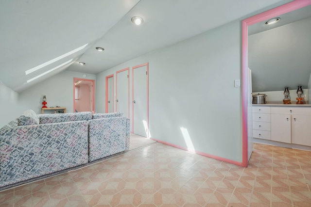 bonus room featuring vaulted ceiling with skylight and baseboards