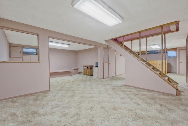 finished basement featuring carpet floors, stairway, and baseboards