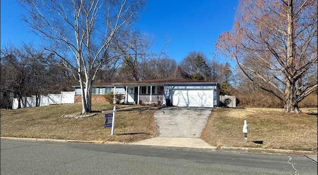 ranch-style home featuring aphalt driveway, an attached garage, covered porch, fence, and a front lawn