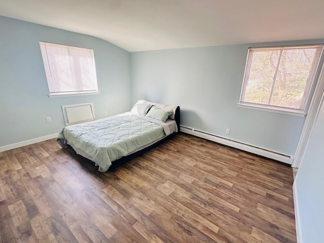 bedroom featuring a baseboard heating unit, lofted ceiling, baseboards, and wood finished floors