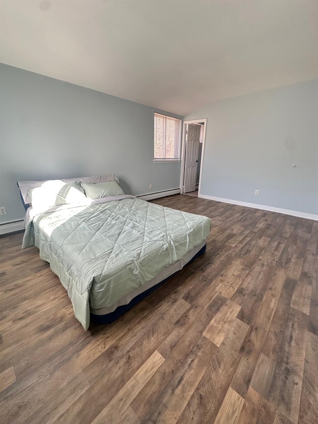 bedroom featuring dark wood-style floors, baseboard heating, and baseboards