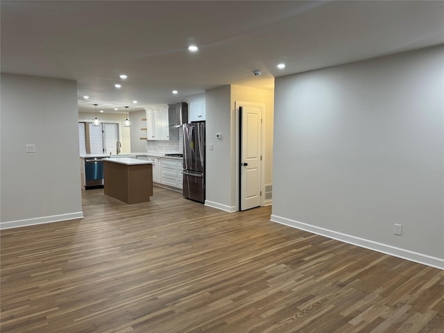 unfurnished living room with recessed lighting, baseboards, and dark wood-type flooring