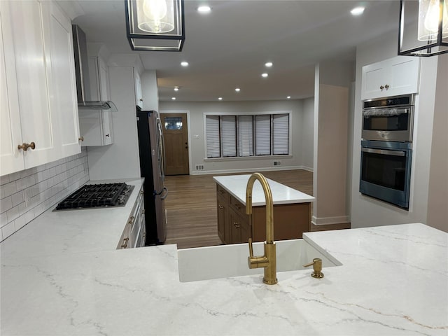 kitchen featuring recessed lighting, stainless steel appliances, tasteful backsplash, and white cabinets