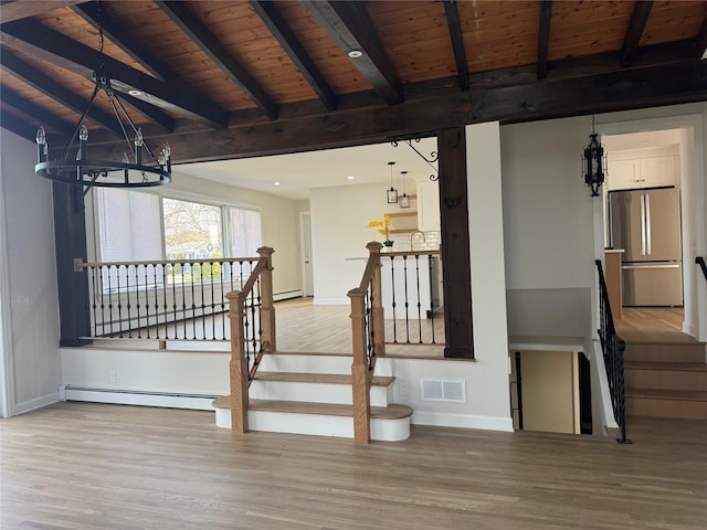 stairs with wood finished floors, visible vents, vaulted ceiling with beams, a notable chandelier, and baseboard heating