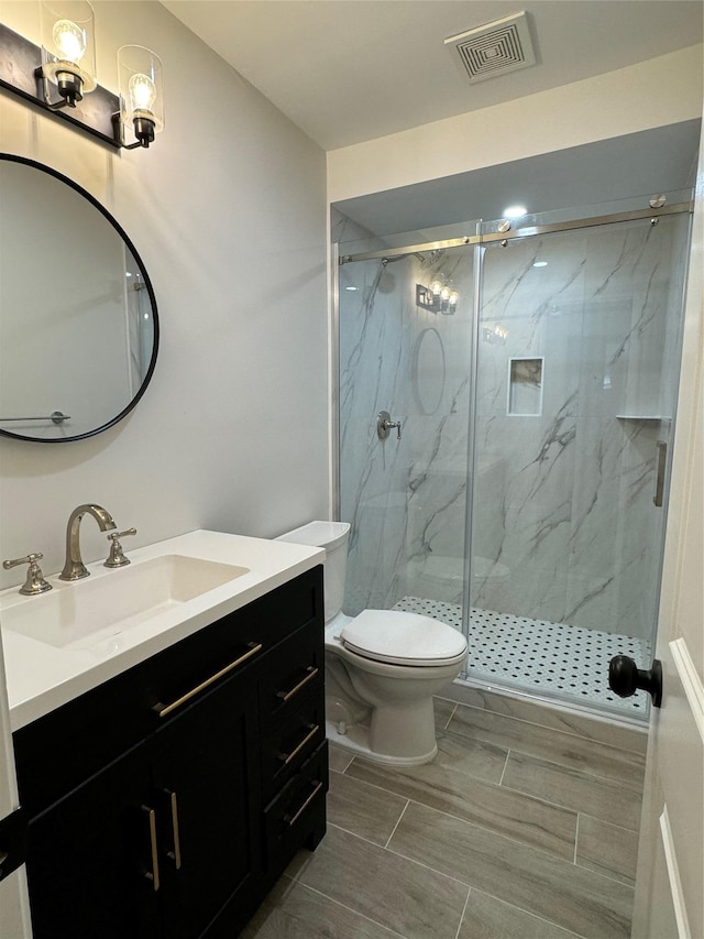 bathroom with a marble finish shower, visible vents, toilet, and vanity