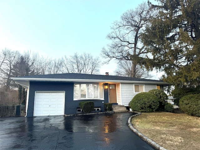 single story home with aphalt driveway, a garage, and fence