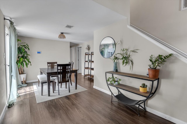 dining area with visible vents, dark wood-style floors, and baseboards