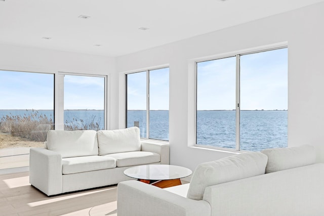 living area with a water view and light wood-style floors