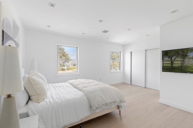 bedroom featuring visible vents, a closet, and light wood-type flooring