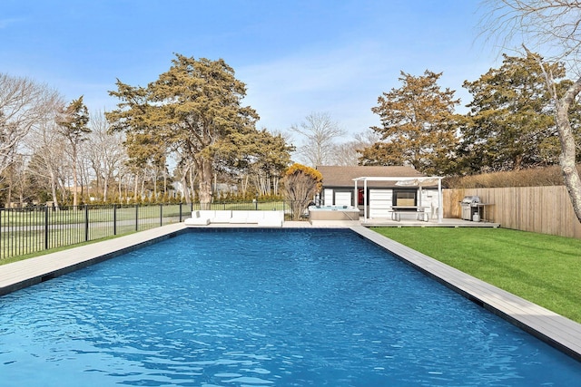 view of swimming pool with a yard, a deck, a fenced in pool, and a fenced backyard