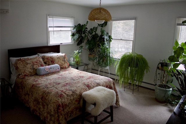 bedroom with multiple windows, a baseboard heating unit, a wall mounted AC, and carpet floors