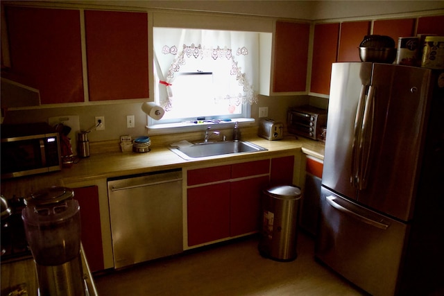 kitchen with a sink, a toaster, appliances with stainless steel finishes, and light countertops