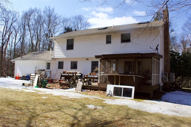 back of house with a sunroom and a chimney