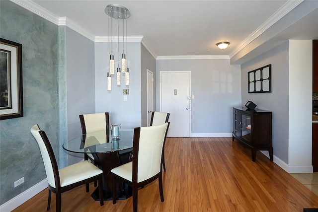 dining room featuring baseboards, wood finished floors, and crown molding