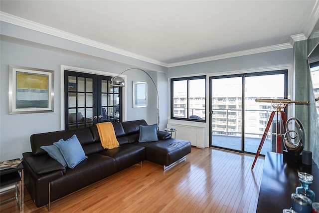 living room with french doors, radiator heating unit, light wood-type flooring, and crown molding