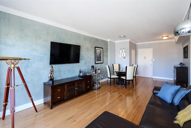 living room featuring light wood-style floors, baseboards, and ornamental molding