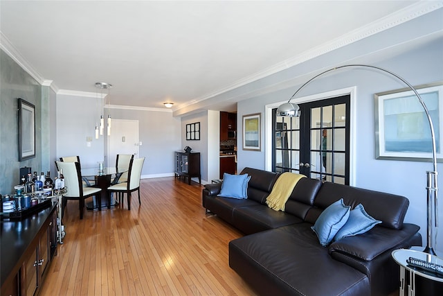 living room featuring ornamental molding, french doors, light wood-type flooring, and baseboards