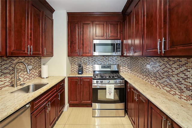 kitchen featuring appliances with stainless steel finishes, a sink, backsplash, and dark brown cabinets