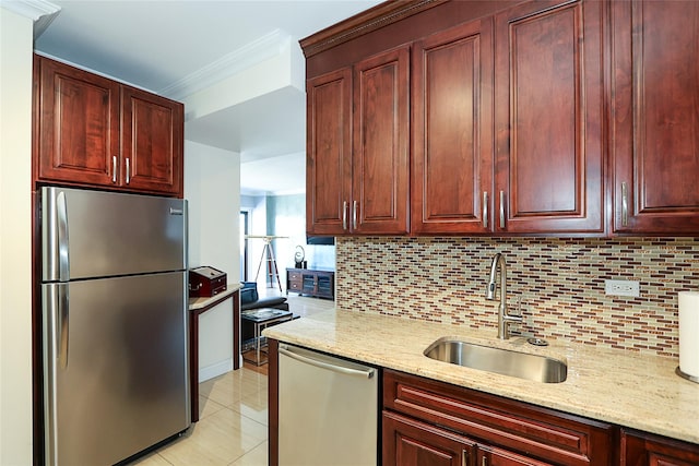 kitchen featuring backsplash, crown molding, stainless steel appliances, and a sink