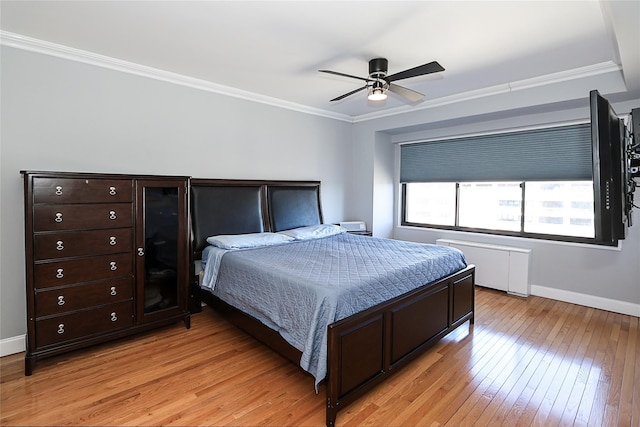 bedroom featuring ceiling fan, light wood-style floors, baseboards, radiator, and crown molding