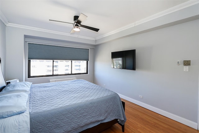 bedroom with baseboards, ornamental molding, ceiling fan, and wood finished floors