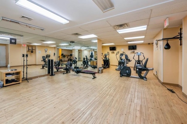 gym featuring a paneled ceiling, visible vents, and wood finished floors